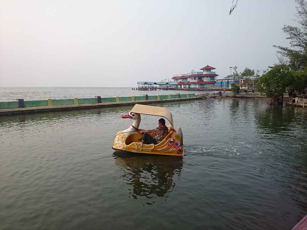 Naik perahu bebek di kolam Pantai Pasir Kencana