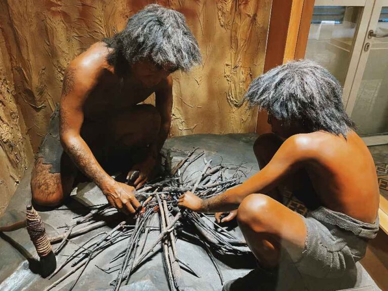 Patung manusia purba yang sedang belajar membuat api