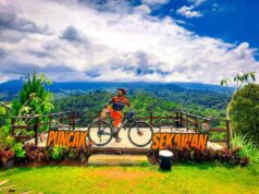 Area berfoto di Puncak Sekawan berlatar perbukitan hijau