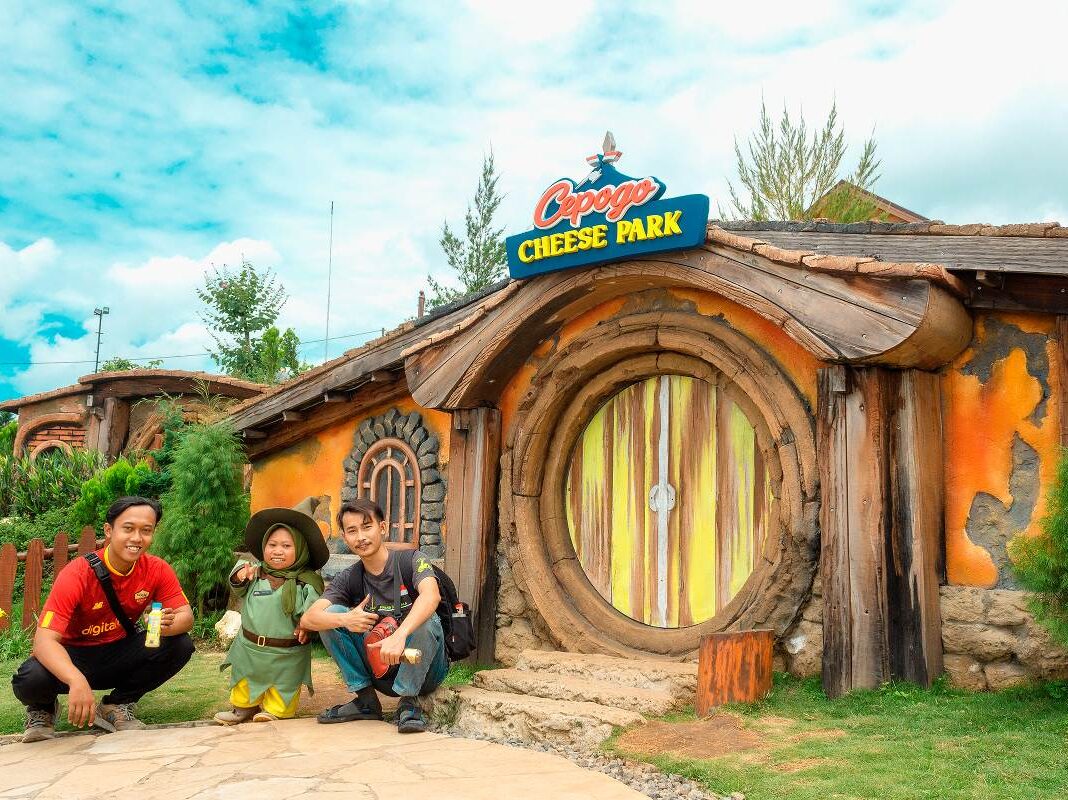 Wisatawan sedang berfoto dengan kurcaci penghuni Rumah Hobbit di Cepogo Cheese Park 