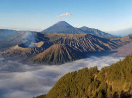 Tiga puncak gunung berselimut lautan awan terlihat dari King Kong Hill