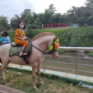 Pengunjung sedang menaiki wahana kuda tunggang di tempat wisata Jaletreng Riverpark