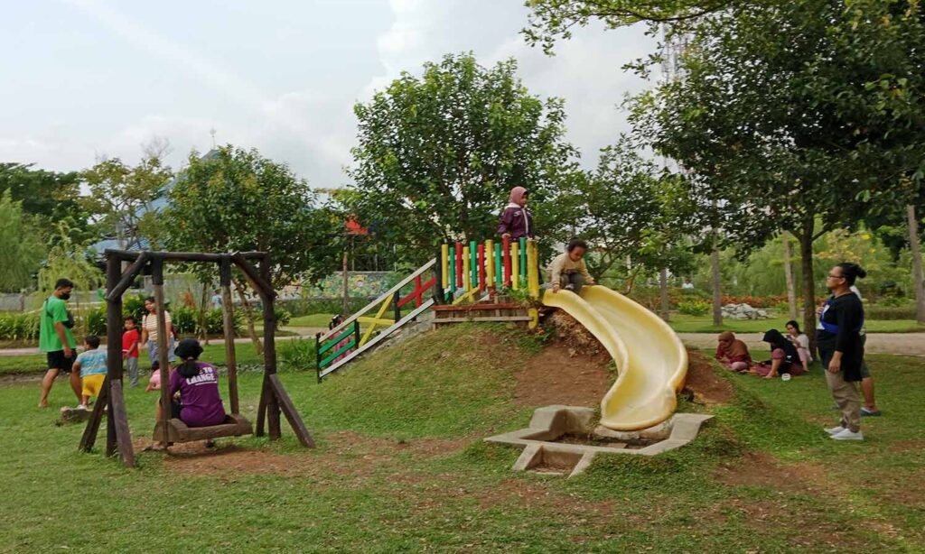 Area bermain anak dengan berbagai wahana seperti perosotan dan ayunan di Jalur Hijau Kosambi